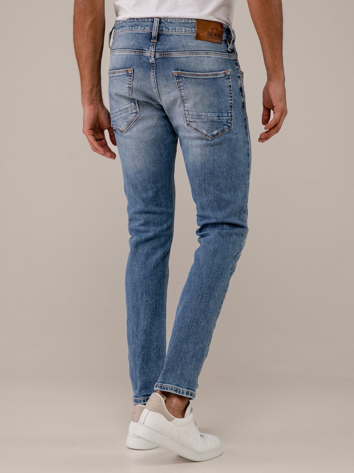 Detailansicht von Destroyed Slim Fit Jeans mit Knopfleiste von THE NIM